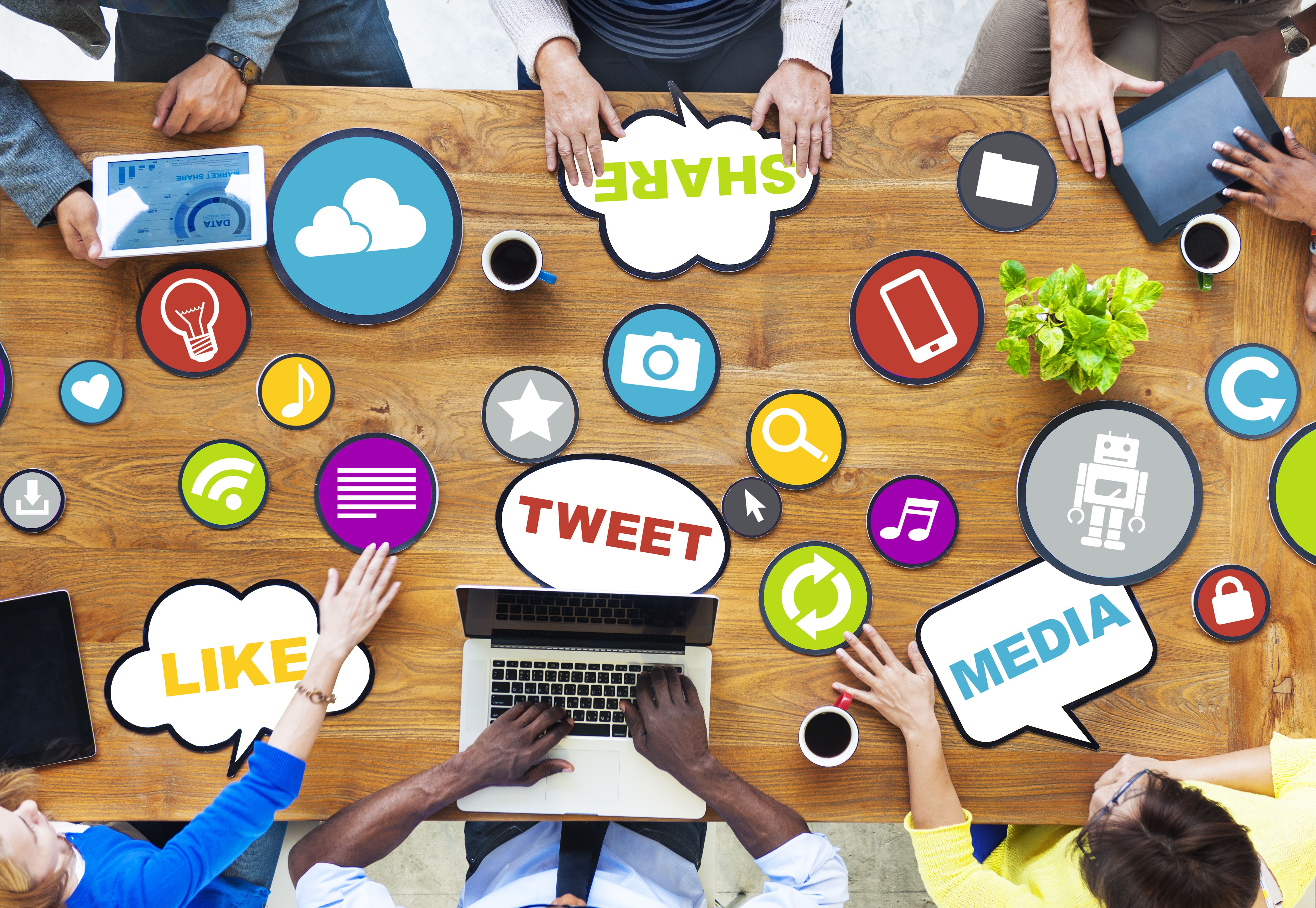 Image of people around a meeting table with emblems relating to social media